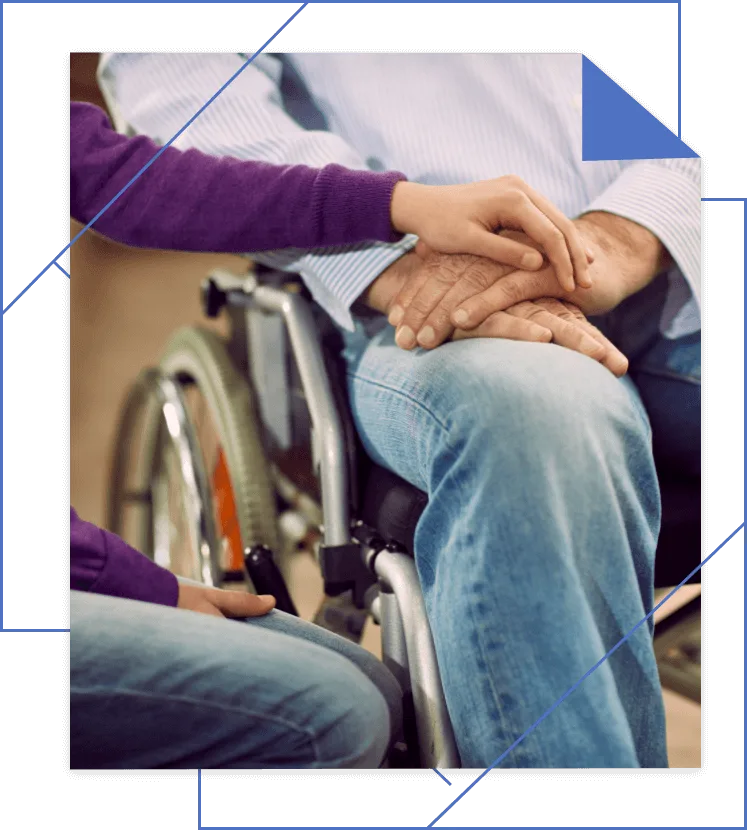 A person in a wheelchair, comforted by another's touch, both clad in jeans. Their journey could benefit from the support of a Michigan personal injury attorney to ensure maximum compensation for their case.