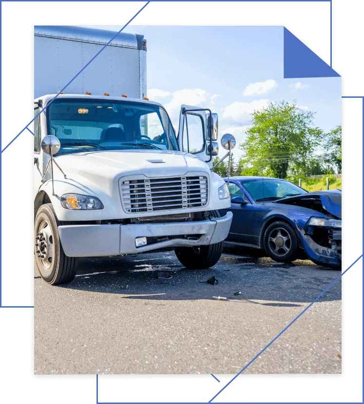 A white truck and dark car collided on the road, leaving the truck's driver-side door open. Debris is scattered around, framed by trees against a clear sky. If you're affected by such incidents, consulting a trucking accident injury lawyer can help navigate your truck accident injury claim.