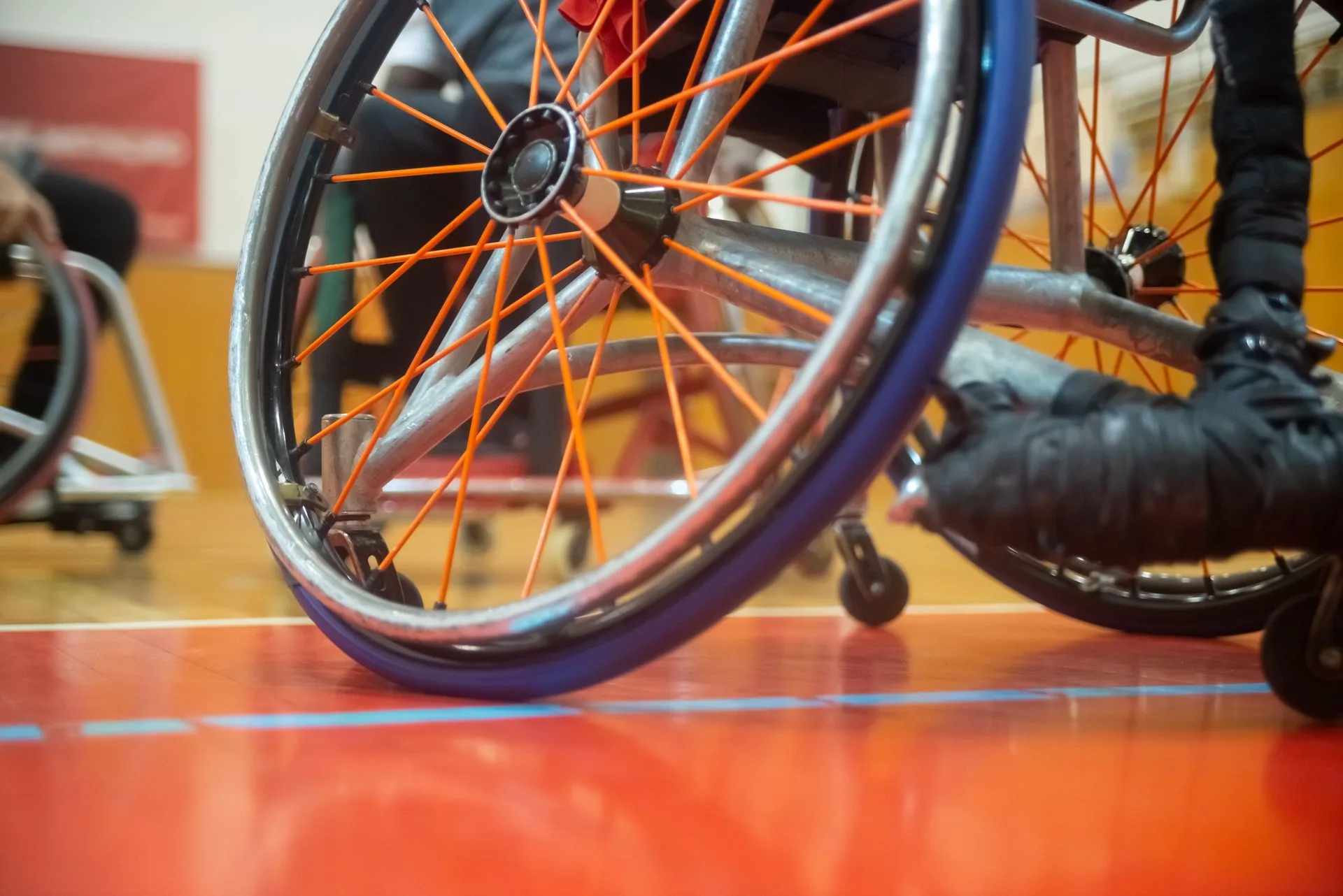 Close-up of a wheelchair wheel on an indoor court