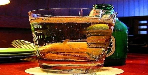 A chilled glass of light beer with a lime wedge sits enticingly on the table beside a green bottle. In places like the Detroit area, where underage drinking poses serious concerns, it’s crucial to enjoy responsibly and avoid contributing to drunk driving accidents.