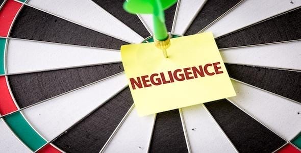 A dart pierces a sticky note labeled "NEGLIGENCE" on a dartboard, underscoring what you need to know about Michigan's laws.
