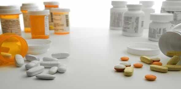 Scattered pills and various prescription bottles on a white surface serve as a stark reminder of the dangers of drugged driving, an issue that Detroit, Michigan is actively addressing to save lives.