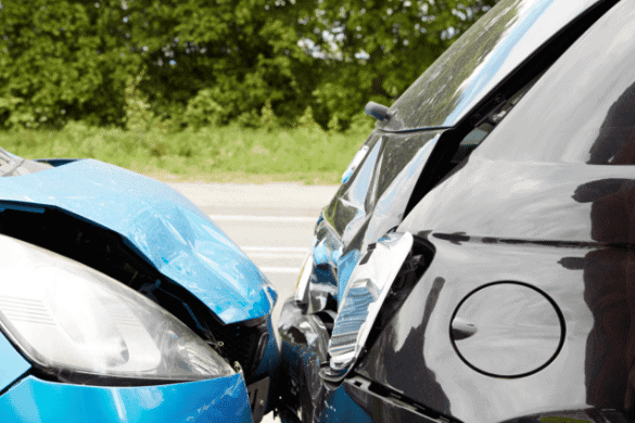 A close-up captures the aftermath of a collision, where the front of a blue car has met the rear of a black vehicle on a tree-lined road. With no-fault insurance benefits, finding a nearby attorney can help navigate this unexpected mishap.
